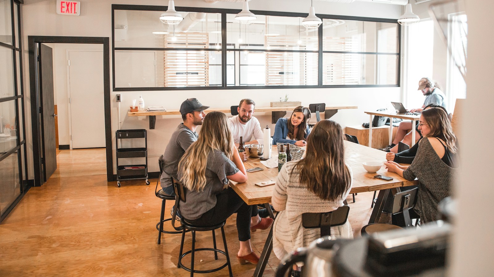 Collega’s lunchen samen aan een lange tafel op kantoor